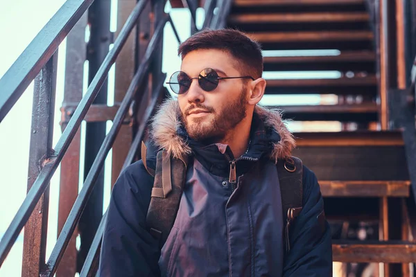 Un joven guapo y elegante sentado en las escaleras afuera . —  Fotos de Stock