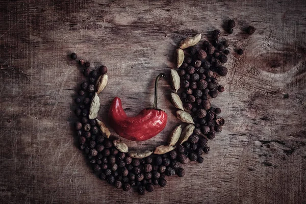 De samenstelling van de bonen, zwarte peper en een rode peper in het midden — Stockfoto