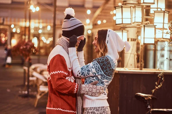 Jovem casal romântico se divertindo e gostando de passar o tempo juntos no Natal na rua decorada com belas luzes . — Fotografia de Stock