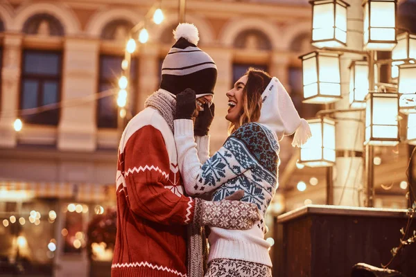 Jovem casal romântico se divertindo e gostando de passar o tempo juntos no Natal na rua decorada com belas luzes . — Fotografia de Stock