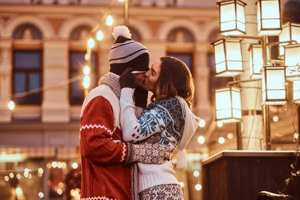 Jovem casal romântico se divertindo e gostando de passar o tempo juntos no Natal na rua decorada com belas luzes . — Fotografia de Stock