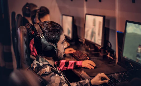 Equipo de jugadores adolescentes juega en un videojuego multijugador en PC en un club de juegos . —  Fotos de Stock