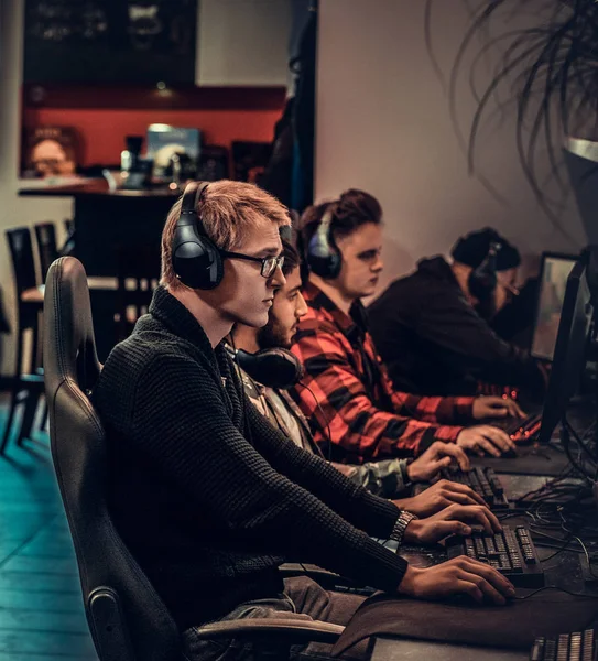 Team of teenage gamers plays in a multiplayer video game on pc in a gaming club. — Stock Photo, Image