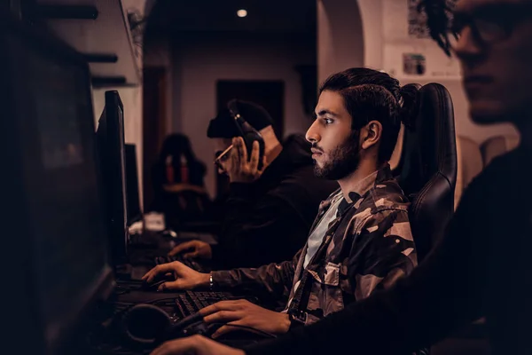 Una joven jugadora india juega en un videojuego multijugador en PC en un club de juegos, disfrutando pasar tiempo con sus amigos . —  Fotos de Stock