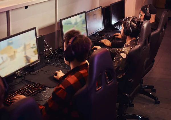 A team of professional cyber sportmans, trains for the championship, plays in a multiplayer video game on pc in a gaming club or internet cafe. — Stock Photo, Image