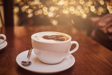 Sıcak kahve bir fincan kahve dükkanı ahşap tablo sanatla, bokeh etkisi ile arka plan bulanıklık