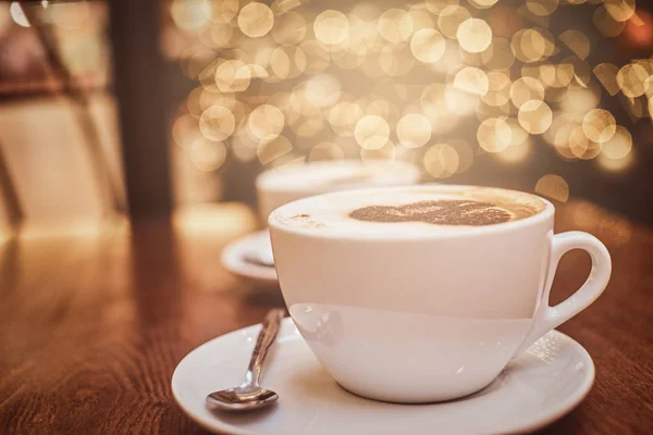 İki fincan sıcak kahve ile sanat bir kafede, ahşap masa üzerinde bokeh etkisi ile arka plan bulanıklık — Stok fotoğraf