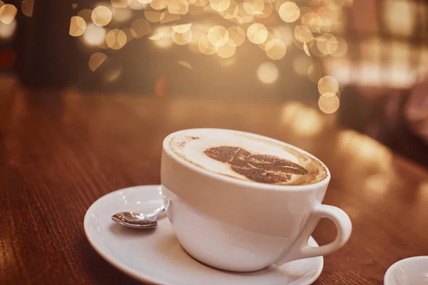 Hete koffie met kunst in een cup op de houten tafel in een koffiehuis, achtergrond bokeh ingaande wazig — Stockfoto