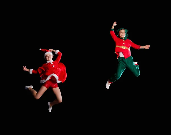 Noël, enfance, conte de fées. Enfants gais - Une jeune fille portant un costume de Père Noël et un garçon portant un costume d'elfe volant ensemble — Photo