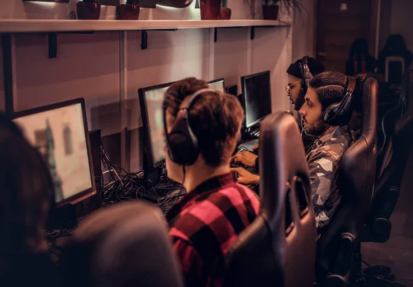 Equipo de jugadores adolescentes juega en un videojuego multijugador en PC en un club de juegos . —  Fotos de Stock