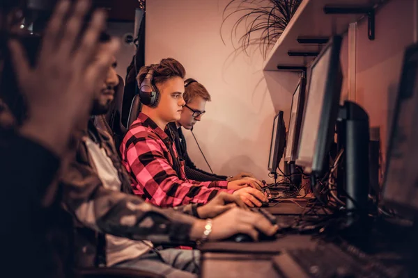 Equipo de jugadores adolescentes juega en un videojuego multijugador en PC en un club de juegos . —  Fotos de Stock