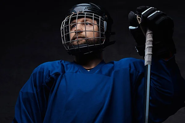 Portrait of a professional ice-hockey player in a hockey uniform. Studio shot. — Stock Photo, Image