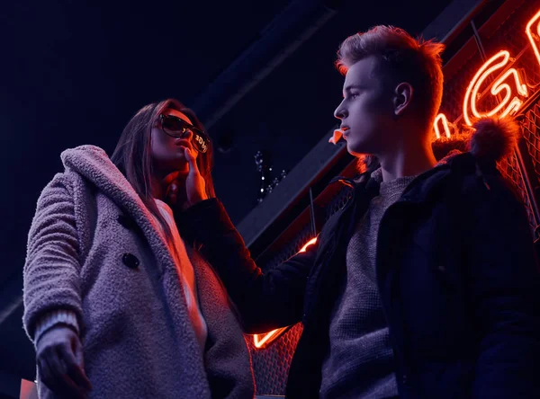Porträtt av en passionerad unga paret tittar på varandra i nattklubben underground med industriella interiören, han rör försiktigt hennes haka — Stockfoto