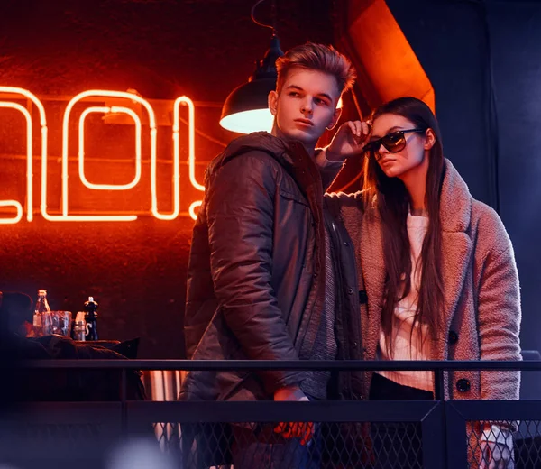 Bir kafede endüstriyel iç ile birlikte poz şık giysiler giyiyor çekici genç çift