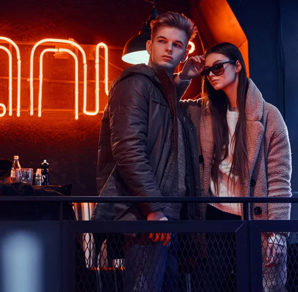 Bir kafede endüstriyel iç ile birlikte poz şık giysiler giyiyor çekici genç çift