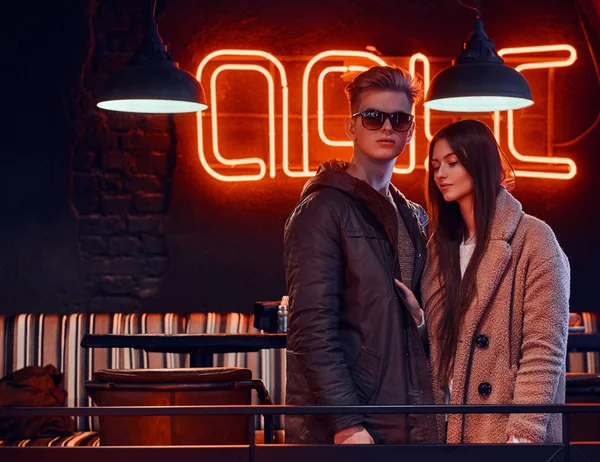 Çekici genç çift birlikte endüstriyel iç bir kafede ayakta şık giysiler giyiyor