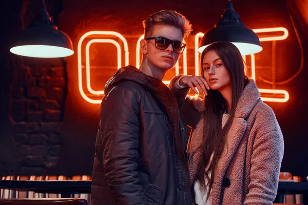 Приваблива молода пара в стильному одязі позує разом в кафе з промисловим інтер'єром — стокове фото