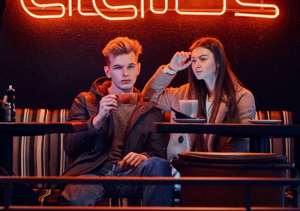 Vestido de moda joven pareja elegante sentado en una cafetería con interior industrial — Foto de Stock