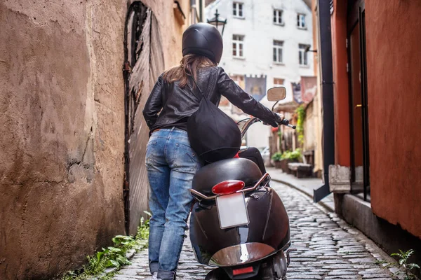 ヨーロッパの古い狭い通りスクーターと歩いている少女の背面図 — ストック写真