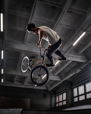 Genç Bmx Bisiklet kapalı skatepark içinde deli hileler yapma.