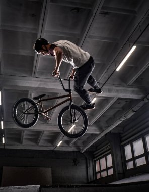 Genç Bmx Bisiklet kapalı skatepark içinde deli hileler yapma.