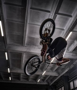 Genç Bmx Bisiklet kapalı skatepark içinde deli hileler yapma.