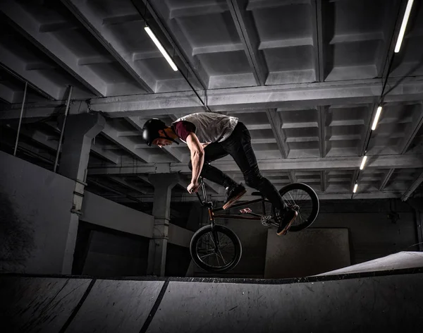 Junger Mann mit BMX zeigt Tricks im Skatepark — Stockfoto