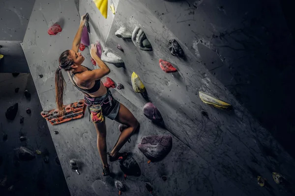 Sportowy kobieta wspinaczkowe sztuczne boulder pomieszczeniu. — Zdjęcie stockowe