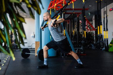 Süspansiyon fitness halat boyu spor salonunda egzersiz sakallı atletik erkek