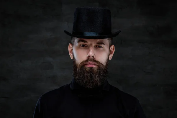 심각한 구식 수염 남자 탑 모자를 쓰고 어두운 배경에 고립 된 카메라를 보고. — 스톡 사진