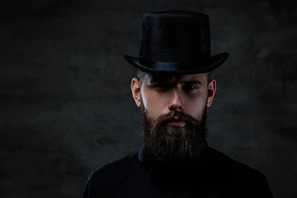 Ciddi bir eski moda bir kamera, karanlık bir arka plan üzerinde izole bakarak bir silindir şapka giyen adam sakallı. — Stok fotoğraf
