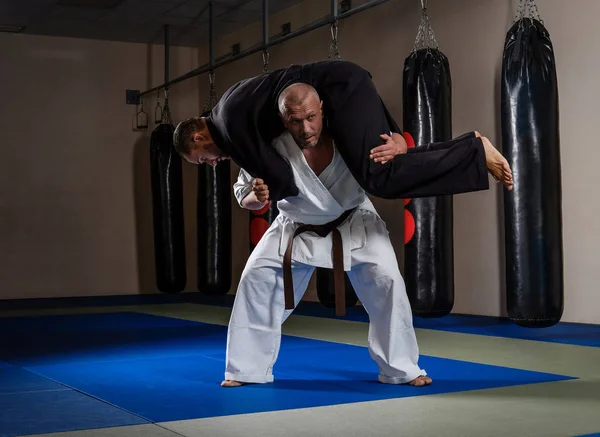 Dos luchadores de karate en kimono mostrando habilidad técnica en un club de lucha —  Fotos de Stock