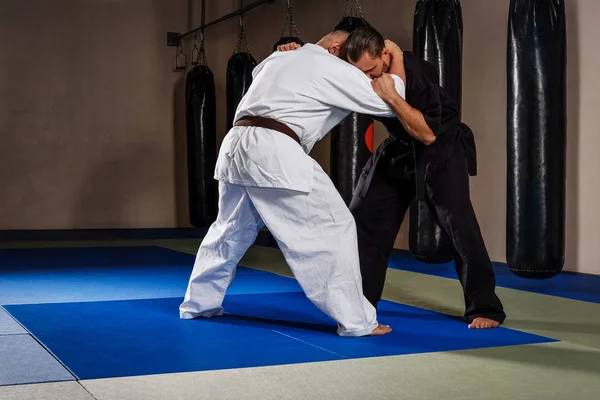 Dos luchadores de karate en kimono mostrando habilidad técnica en un club de lucha — Foto de Stock