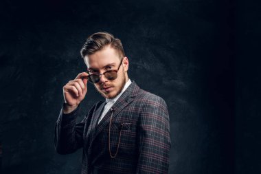 Zarif bir karanlık dokulu duvara güneş gözlüklü genç adam giyinmiş