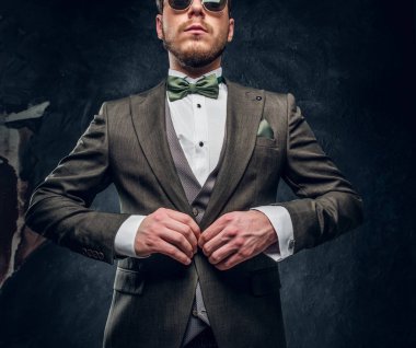 Zarif ceketini karanlık dokulu duvara kadar düğmelerini şık bir adam