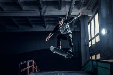 Genç kaykaycı mini rampa skate park kapalı bir numara performans. 