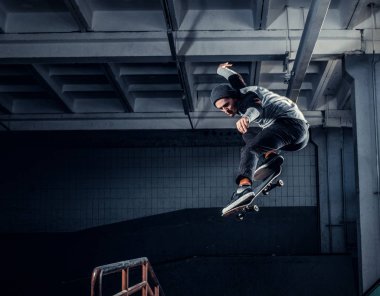 Genç kaykaycı mini rampa skate park kapalı bir numara performans. 