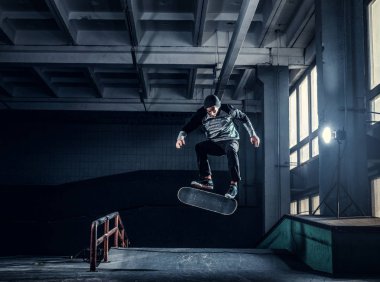 Genç kaykaycı mini rampa skate park kapalı bir numara performans. 