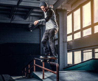 Genç kaykaycı mini rampa skate park kapalı bir numara performans. 