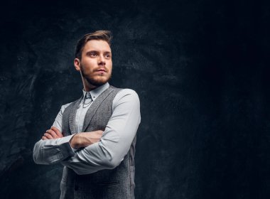 Genç bir zarif giyimli adam kollarını ile poz bir stüdyoda geçti