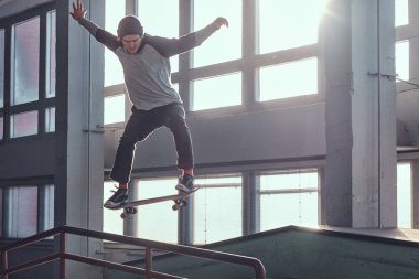 Genç kaykaycı mini rampa skate park kapalı bir numara performans. 