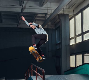 Genç kaykaycı mini rampa skate park kapalı bir numara performans. 