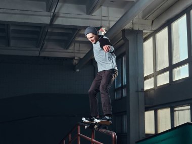 Genç kaykaycı mini rampa skate park kapalı bir numara performans. 