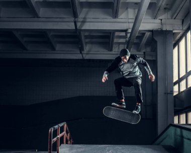 Genç kaykaycı mini rampa skate park kapalı bir numara performans. 