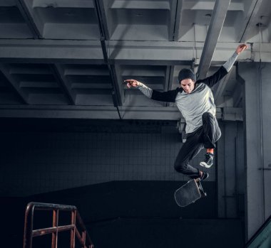 Genç kaykaycı mini rampa skate park kapalı bir numara performans. 