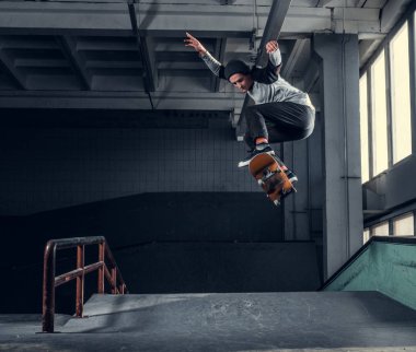 Genç kaykaycı mini rampa skate park kapalı bir numara performans. 