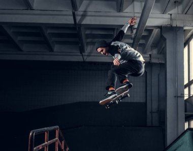 Genç kaykaycı mini rampa skate park kapalı bir numara performans. 