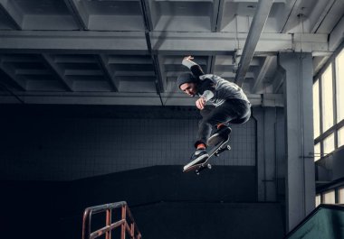 Genç kaykaycı mini rampa skate park kapalı bir numara performans. 