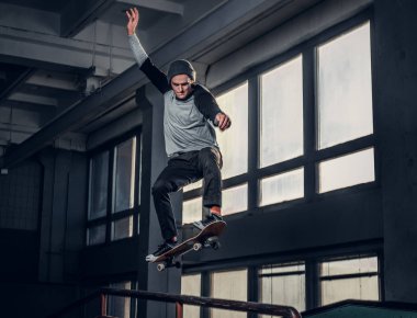 Genç kaykaycı mini rampa skate park kapalı bir numara performans. 