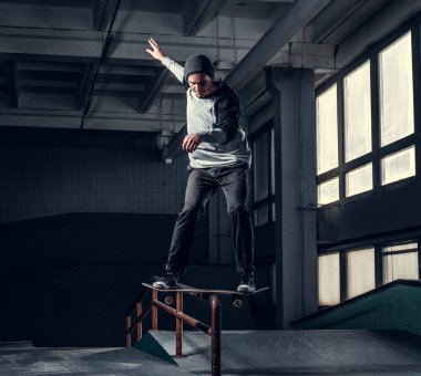 Genç kaykaycı mini rampa skate park kapalı bir numara performans. 